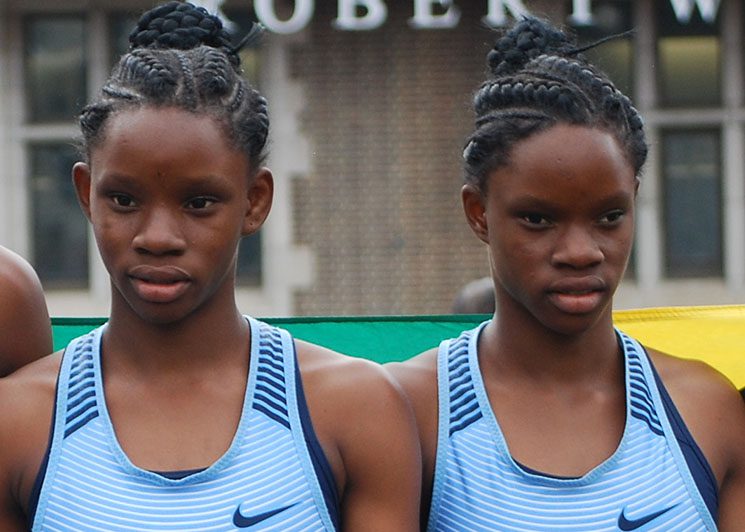 Two twin looking girls standing at a place